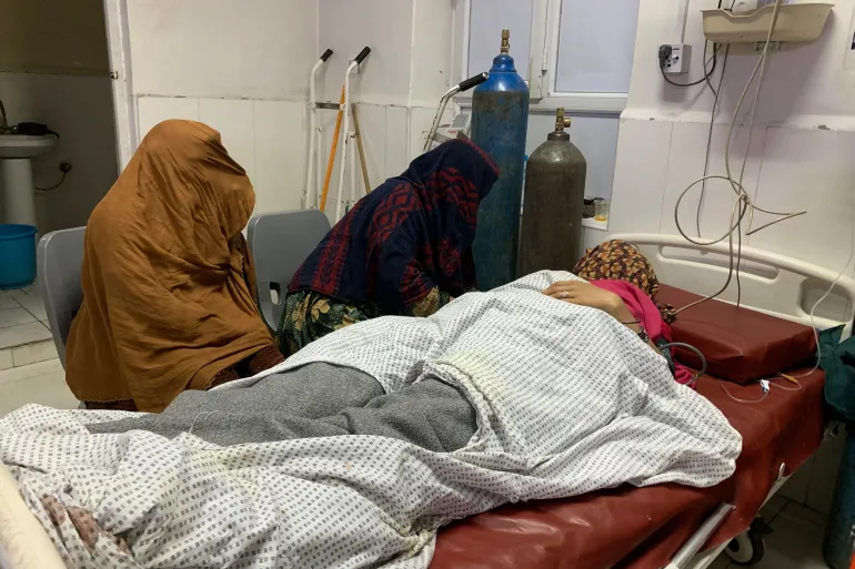 TOPSHOT - An injured Afghan woman receives treatment at a hospital in Jalalabad on February 27, 2026, after a Pakistani mortar shell hit a camp for people returning from Pakistan, during ongoing clashes between Pakistani forces and Taliban security personnel near the Torkham border crossing between Afghanistan and Pakistan in Nangarhar province.