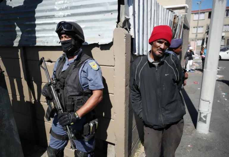Residents look on as police wait as South African President Cyril Ramaphosa visits crime-ridden Hanover Park to launch a new Anti-Gang Unit in Cape Town, South Africa, November 2, 2018. REUTERS/Mike Hutchings