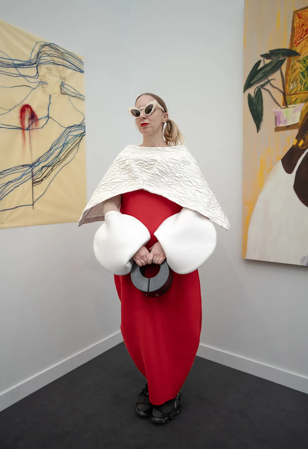 एलए डिजाइनर/कलाकार एलियोना कोनोनोवा अपनी खुद की अलौकिक, अवांट-गार्डे कृतियों का मॉडल तैयार करती हैं। सिल्क केप और कफ अलग-अलग हैं।