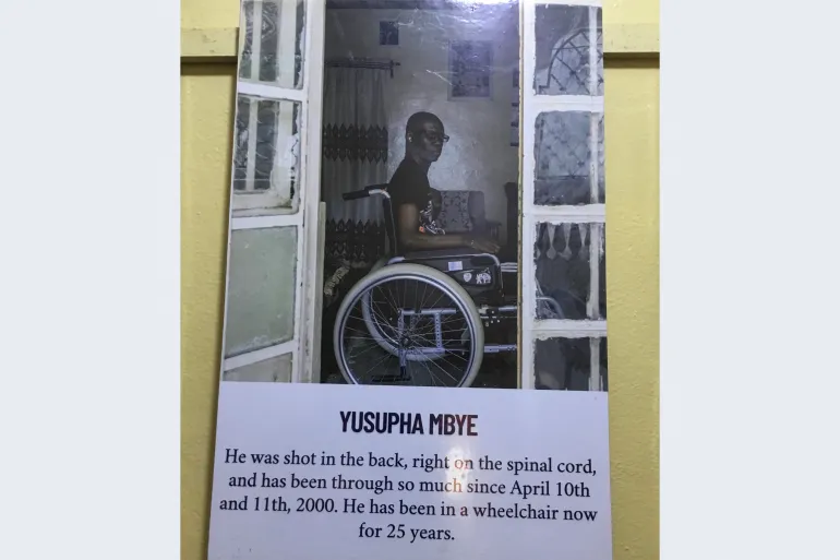 Yusupha se foto hang teen die muur van die Victims' Centre.