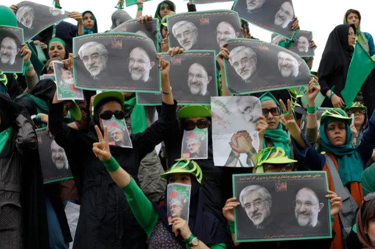 Supporters of Iran's presidential election candidate Mirhossein Mousavi carry posters with images of Mousavi (L) and former Iranian President Mohammad Khatami during a campaign rally in Tehran June 9, 2009. REUTERS/Ahmed Jadallah (IRAN POLITICS ELECTIONS)
