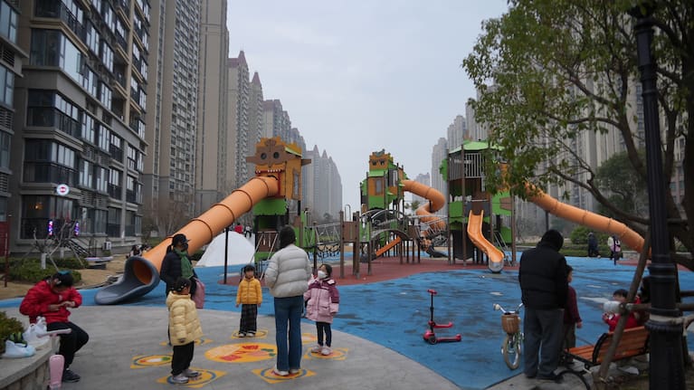 निवासी अपने बच्चों के साथ अर्ध-परित्यक्त खेल के मैदान में खेलते हैं "वेनिस में जीवन" आवासीय परिसर