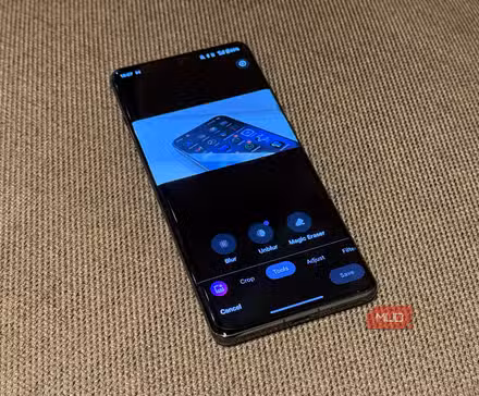 फ़ोन को भौतिक सतह पर रखा गया है और Google फ़ोटो संपादन मेनू खुला हुआ है जिसमें उसका टूल टैब दिखाई दे रहा है