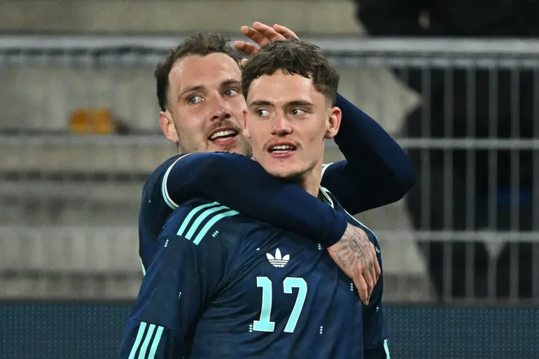 Germany midfielder #17 Florian Wirtz celebrates his team's third goal with Germany defender #22 David Raum during the international friendly soccer match between Switzerland and Germany at St. Jakob Park in Basel, Switzerland on March 27, 2026. (Photo by Fabrice COFFRINI / AFP)