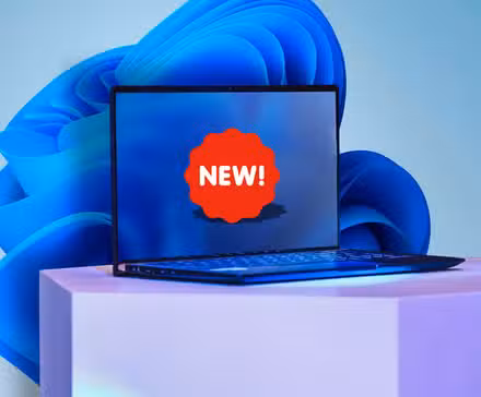 स्क्रीन पर नए स्टिकर वाला एक लैपटॉप और पृष्ठभूमि में विंडोज 11 वॉलपेपर