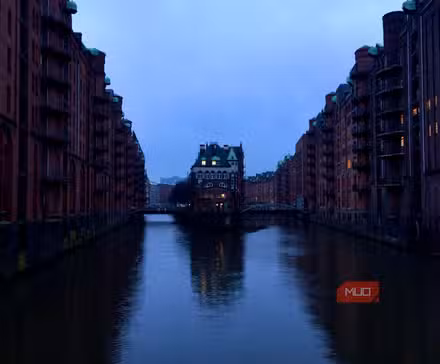 एक शहर में शाम को एक नदी पर प्रतिबिंब