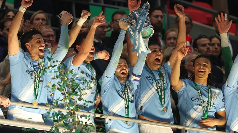 Bernardo Silva lifts the Carabao Cup as his Man City teammates celebrate