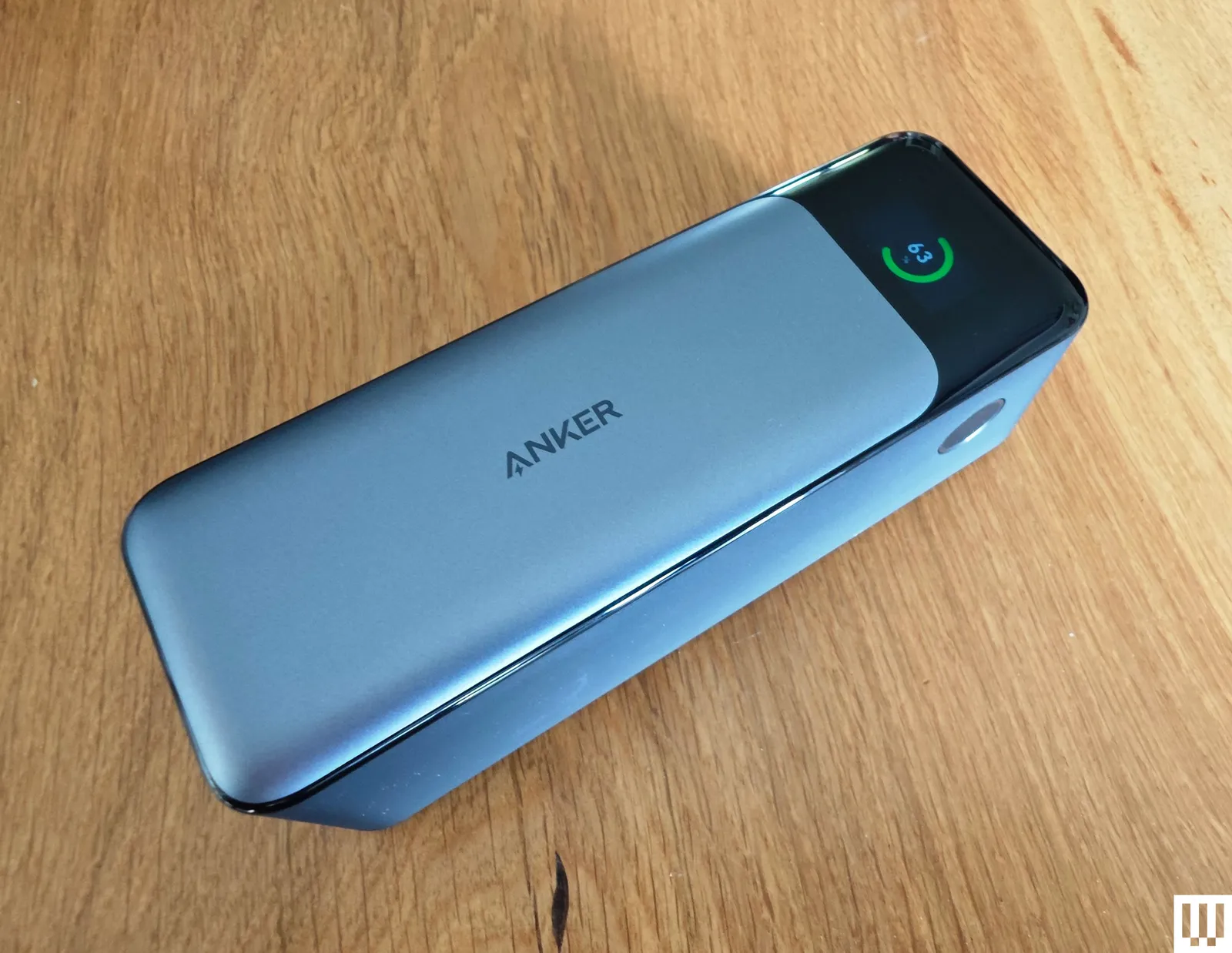 Silver rectangular portable charger with a narrow screen at the end